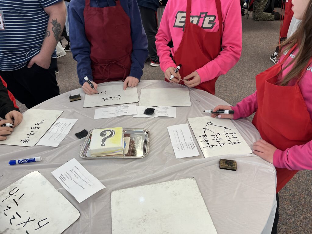 Students standing around table participating in Math-ter Chef activity